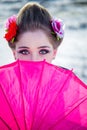 geisha hiding face behind pink umbrella
