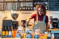 Portrait of a genderqueer barista making coffee at counter in coffee shop