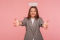 Portrait of generous woman in business suit with angelic appearance and halo over her head raising hands to embrace