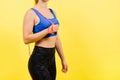 Portrait of gentle muscular woman holding skipping rope on her neck isolated over yellow background Royalty Free Stock Photo