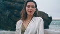 Portrait serene girl dancing in front rocky cloudy seascape. Woman moving hands.