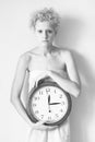 Portrait of a gentle young girls with big clock in his hands.