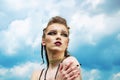 Portrait of a girl with aggressive make-up war paint indian amazon posing against the sky on nature Royalty Free Stock Photo