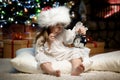 Portrait of girl with alarm clock under the Christmas tree