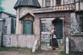 Portrait of a girl in ancient clothes at the gate to the courtyard of a retro Church in medieval Europe