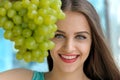 Portrait of a girl behind bunch of ripe grapes