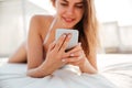 Portrait of a girl in bikini lying and using smartphone Royalty Free Stock Photo