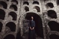 Portrait of a girl in a black dress with a white collar standing in a stone opening. Royalty Free Stock Photo