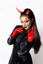 Portrait of a girl in a black leather cloak and red gloves, with horns on her head Royalty Free Stock Photo