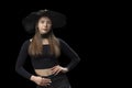 Portrait of girl in black short top, jeans and wide-brimmed hat in the studio. Copy space, mockup. Black background Royalty Free Stock Photo