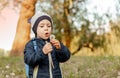 Portrait of a girl blowing on a dandelion flower in the open air. Royalty Free Stock Photo