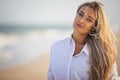 Portrait of a girl in a blue swimsuit and white shirt against the background of the blue sea and clear sky Royalty Free Stock Photo