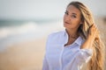 Portrait of a girl in a blue swimsuit and white shirt against the background of the blue sea and clear sky Royalty Free Stock Photo
