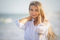 Portrait of a girl in a blue swimsuit and white shirt against the background of the blue sea and clear sky Royalty Free Stock Photo