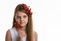 Portrait of a girl with a bunch of berries in her hair, as well as with a bunch in her hand