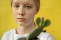 portrait of a girl with a cactus on a yellow background Royalty Free Stock Photo