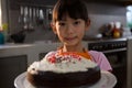Portrait of girl with cake standing in kitchen Royalty Free Stock Photo