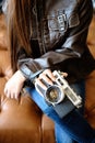 Portrait of a girl with camera sitting on leather sofa