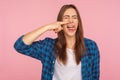 Portrait of girl in checkered shirt picking nose pulling out boogers with disgust expression, bad manners