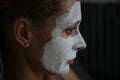 Portrait of a girl with a clay mask on the face