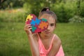 Portrait of girl covering eye with heart-card decorated with puzzle fragments Royalty Free Stock Photo