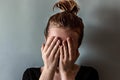 Portrait of a girl covering her face with the palms of her hands. The concept of psychological problems and stress