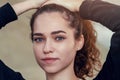 Portrait of girl with curly hair, raises hair with her hands on Royalty Free Stock Photo