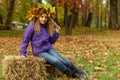 Portrait of a girl with a deciduous wreath. Girl on a hay sheaf.