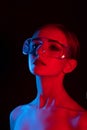 Portrait of  girl in  disco style with blue and red light, girl in transparent big glasses with big eyes and smooth skin Royalty Free Stock Photo