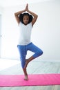 Portrait of girl doing tree pose yoga in room Royalty Free Stock Photo