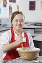 Portrait of girl (10-12) with Down syndrome mixing contents in bowl