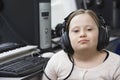 Portrait of girl (10-12) with Down syndrome wearing headphones in home recording studio Royalty Free Stock Photo