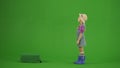 Portrait of girl in dress and rubber boots on chroma key green screen. Small cute girl gardener standing and looking up