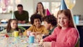 Portrait Of Girl Eating Birthday Cake At Party With Parents And Friends At Home Royalty Free Stock Photo