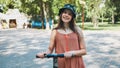 Portrait of a girl on an electric scooter posing in a park in the summer. Royalty Free Stock Photo