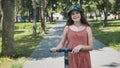 Portrait of a girl on an electric scooter posing in a park in the summer. Royalty Free Stock Photo