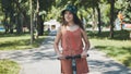 Portrait of a girl on an electric scooter riding in a park in the summer. Royalty Free Stock Photo