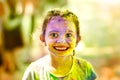 Portrait of girl with face smeared with holi colors in sunny summer day. Concept for Indian festival Holi. Little 6 years old Royalty Free Stock Photo