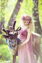 Portrait of a girl in a fairy dress next to a reindeer
