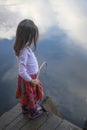 Portrait of a girl fishing in lake reflecting the sky Royalty Free Stock Photo