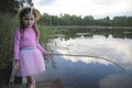 Portrait of a girl fishing in lake reflecting the sky Royalty Free Stock Photo