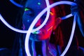 Portrait of a Girl with Glowing Tubes in Neon UF Light. Model Girl with Dreadlocks and Fluorescent Creative Psychedelic