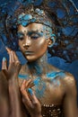 a girl in gold blue creative makeup and headdress