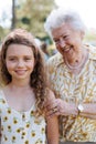 Portrait of girl with grandmother at garden party. Love and closeness between grandparent and grandchild.