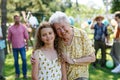 Portrait of girl with grandmother at garden party. Love and closeness between grandparent and grandchild.