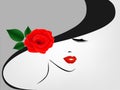 Portrait of a girl in a hat with a red rose on a gray background. Royalty Free Stock Photo