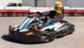 Girl driving kart at racing track outdoors