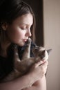 portrait of a girl holding her kitten indoors Royalty Free Stock Photo