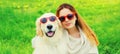 Portrait girl with her Golden Retriever dog wearing a sunglasses on green grass Royalty Free Stock Photo