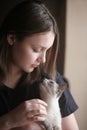 portrait of a girl holding her kitten indoors Royalty Free Stock Photo